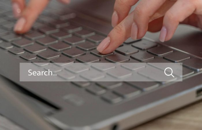 Personne qui écrit sur un ordinateur avec une barre de recherche